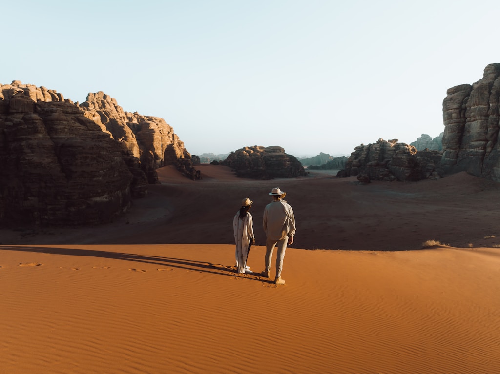 Two people walking together through a vast desert landscape